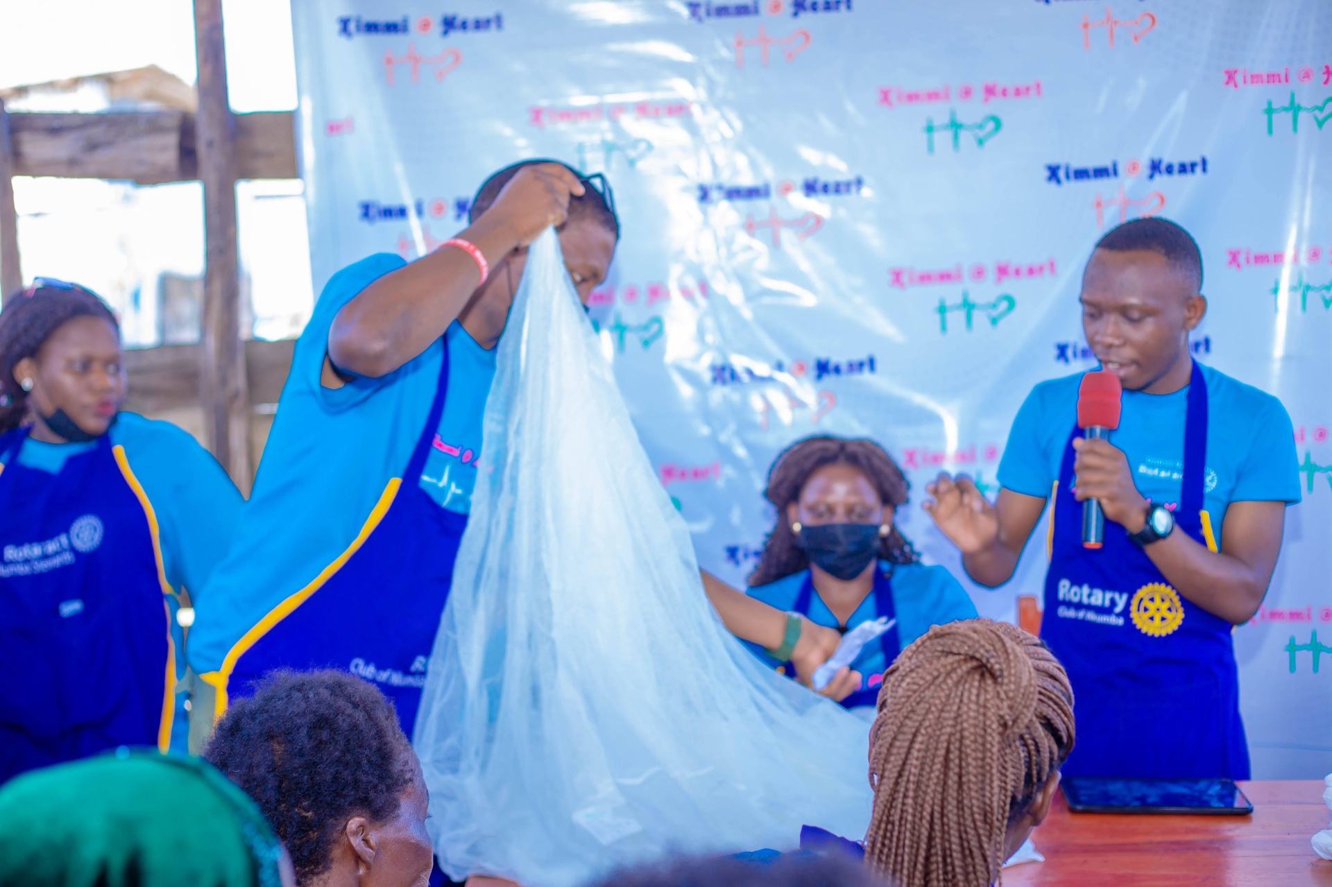 Facilitators demonstrating reusable sanitary towel materials to community members on Kimi Island